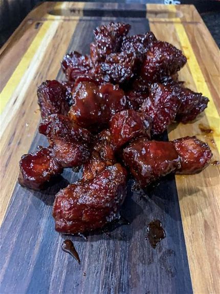 A wooden cutting board with some meat on it