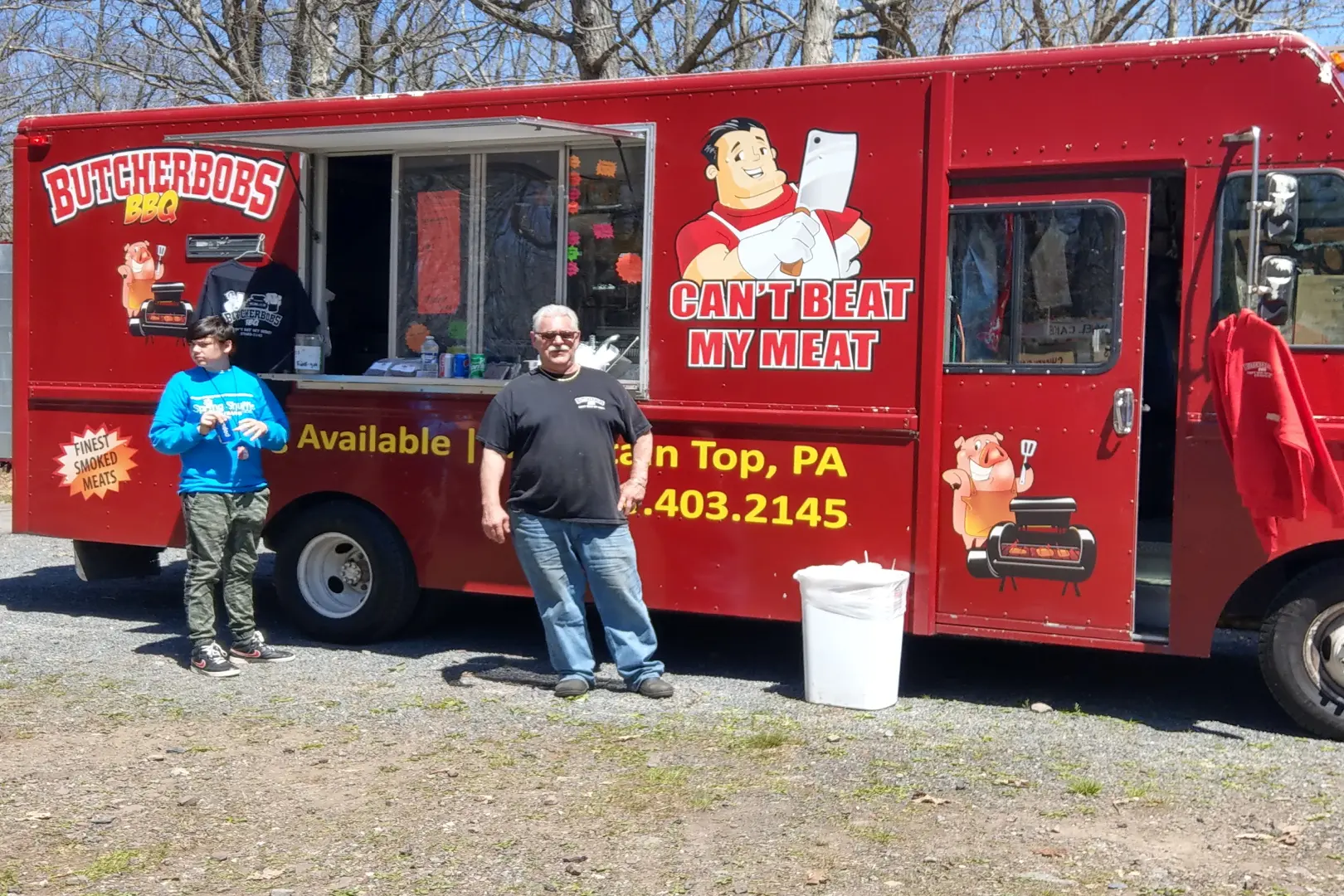 A man standing next to a food truck.